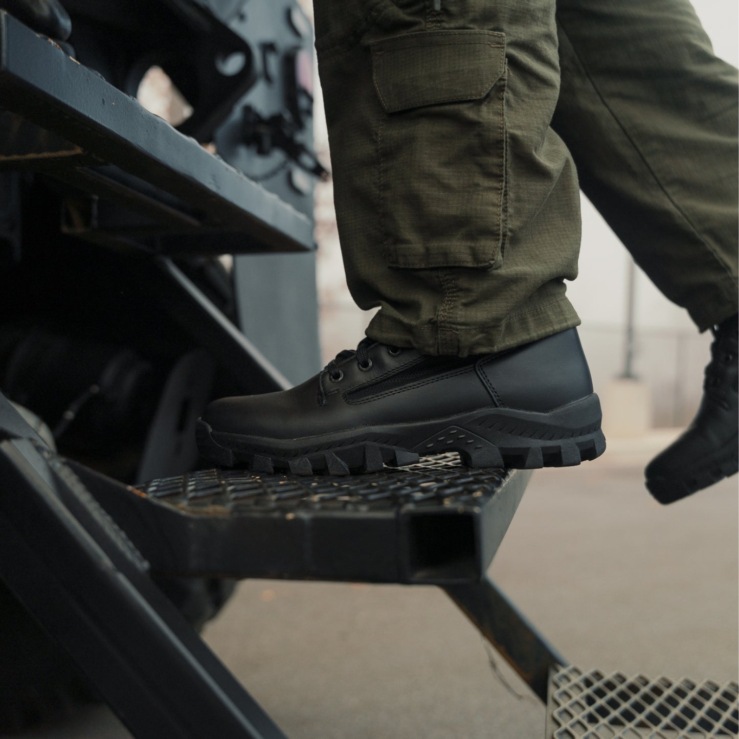 Garmont T8 Defense LE black tactical boot worn on vehicle step with tactical uniform pants