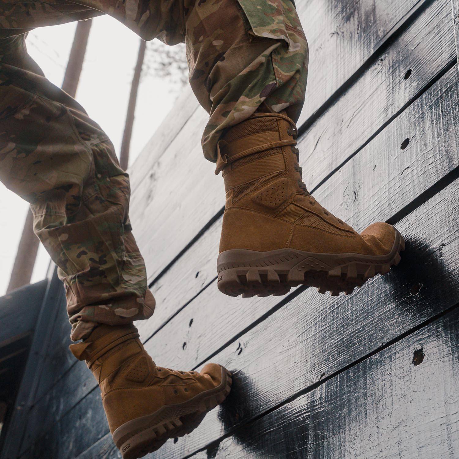 Close-up of coyote military boots worn in action climbing wall - rugged suede uppers and lug soles
