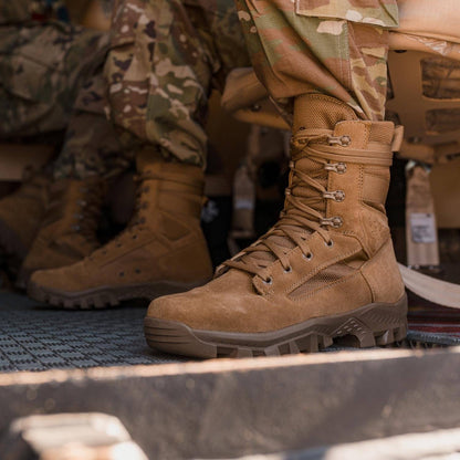 Garmont T8 Defense coyote boot worn with camouflage uniform on vehicle step, side profile close-up