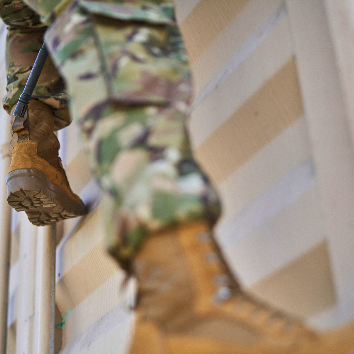 Garmont T8 Bifida USMC Coyote Brown tactical boots worn with camouflage uniforms during military obstacle course training, showcasing rugged traction and field performance.