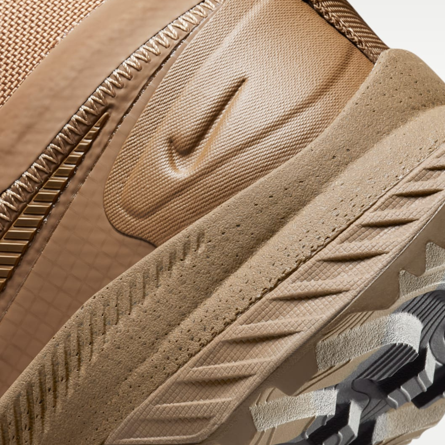 An intricate close-up of the textured midfoot section and debossed Swoosh on the Nike React SFB Carbon Mid Coyote Tactical Boots.