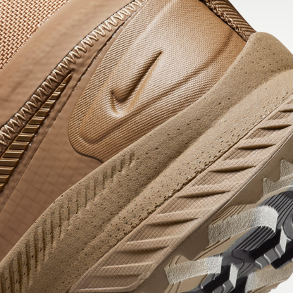 An intricate close-up of the textured midfoot section and debossed Swoosh on the Nike React SFB Carbon Mid Coyote Tactical Boots.